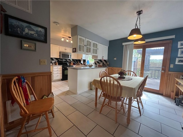 427 Church St, Winfield, NY 13491 - dining space featuring a wainscoted wall, light tile patterned floors, and wooden walls