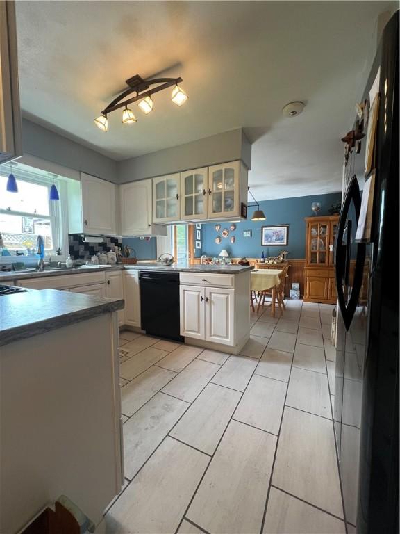 427 Church St, Winfield, NY 13491 - kitchen with black appliances, white cabinetry, glass insert cabinets, a sink, and a peninsula