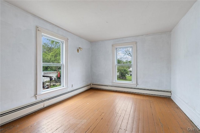8 Washington St, Alexandria, NY 13607 - unfurnished room featuring wood-type flooring, a baseboard heating unit, and healthy amount of natural light