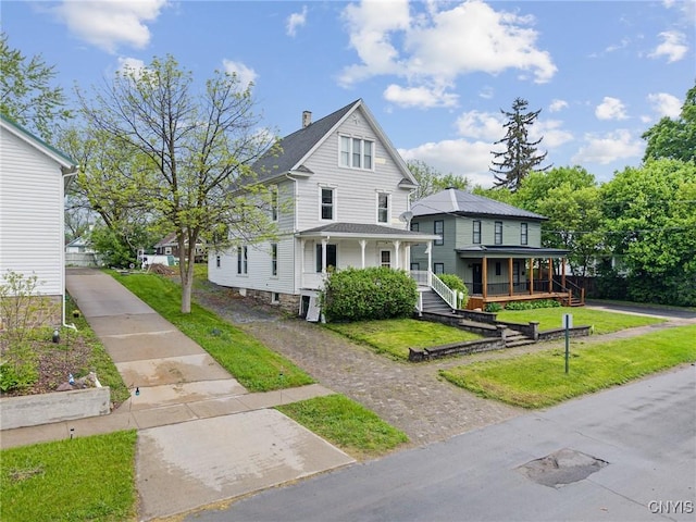 8 Washington St, Alexandria, NY 13607 - view of front of property with covered porch and a front lawn