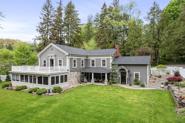 3721 Cold Springs Rd, Lysander, NY 13027 - rear view of property featuring a sunroom, a chimney, a lawn, roof with shingles, and a patio