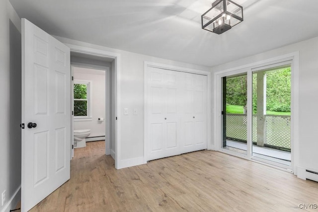 3721 Cold Springs Rd, Lysander, NY 13027 - unfurnished bedroom with access to outside, baseboard heating, light wood-type flooring, baseboards, and a closet