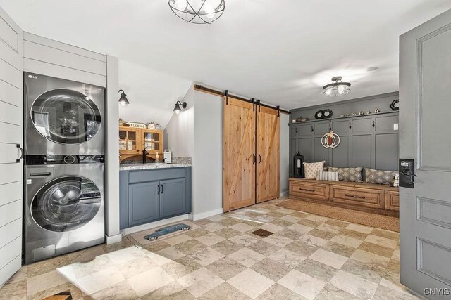 3721 Cold Springs Rd, Lysander, NY 13027 - laundry area with stacked washer / drying machine, a barn door, and baseboards