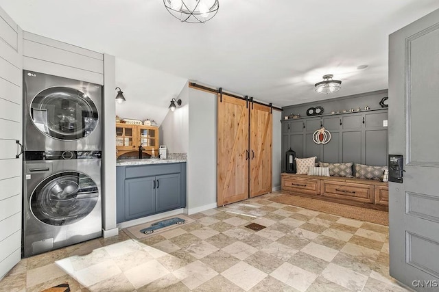 3721 Cold Springs Rd, Lysander, NY 13027 - laundry room featuring stacked washing machine and dryer and a barn door