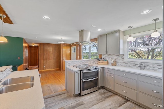 kitchen featuring range with two ovens, gray cabinets, island exhaust hood, light countertops, and recessed lighting