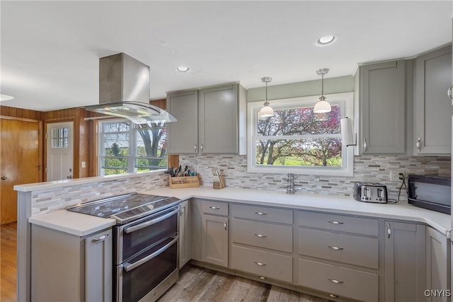 kitchen with gray cabinetry, double oven range, island range hood, and recessed lighting