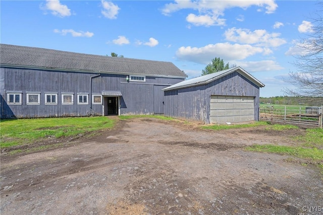 view of outbuilding featuring fence and an outbuilding