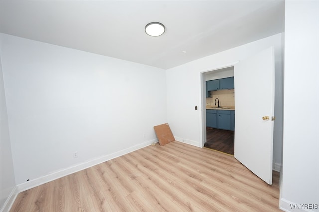 8 Wagner Ave, Cheektowaga, NY 14206 - empty room with light wood-type flooring, a sink, and baseboards