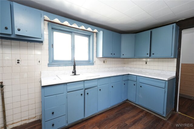 8 Wagner Ave, Cheektowaga, NY 14206 - kitchen with blue cabinetry, a sink, dark wood-style flooring, light countertops, and tasteful backsplash
