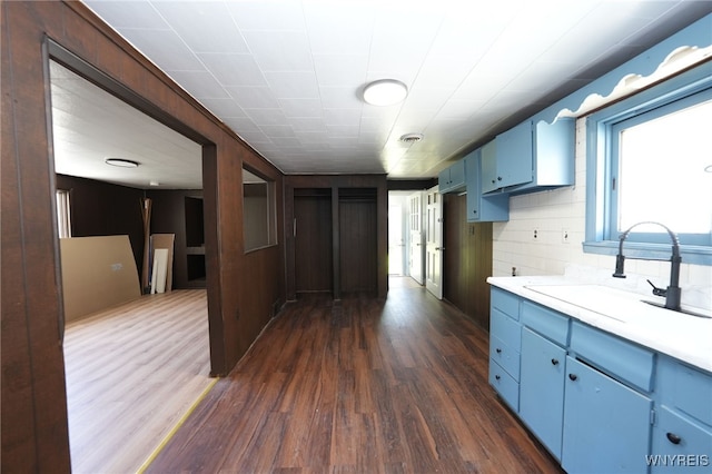 8 Wagner Ave, Cheektowaga, NY 14206 - kitchen featuring blue cabinetry, a sink, dark wood-style flooring, and light countertops