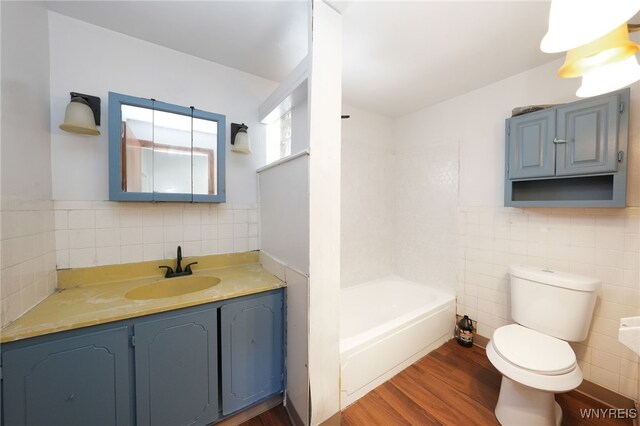 8 Wagner Ave, Cheektowaga, NY 14206 - full bath featuring tile walls, wood finished floors, toilet, vanity, and bathtub / shower combination