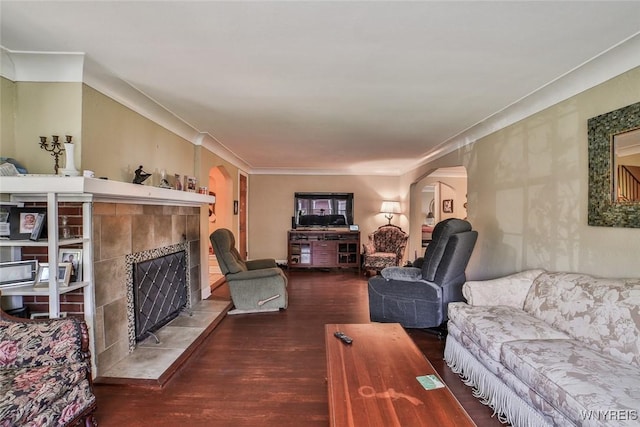 696 Cleveland Dr, Cheektowaga, NY 14225 - living room with arched walkways, wood finished floors, a tiled fireplace, and crown molding