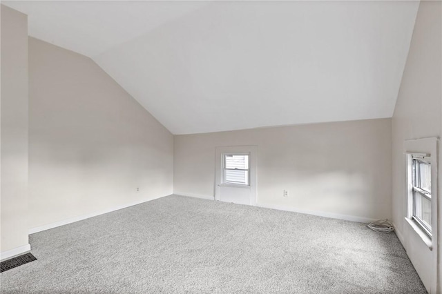 additional living space with vaulted ceiling, carpet flooring, and baseboards