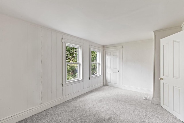 spare room featuring carpet flooring and baseboards