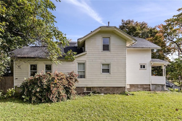 view of side of property with a yard and a shingled roof