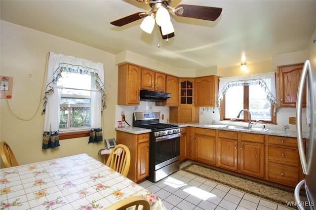 150 Leonard St, Lackawanna, NY 14218 - kitchen with stainless steel appliances, under cabinet range hood, a sink, brown cabinets, and light tile patterned floors