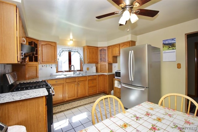 150 Leonard St, Lackawanna, NY 14218 - kitchen with stainless steel appliances, a sink, light countertops, exhaust hood, and light tile patterned floors