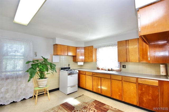 150 Leonard St, Lackawanna, NY 14218 - kitchen featuring white gas stove, a sink, light countertops, and brown cabinetry