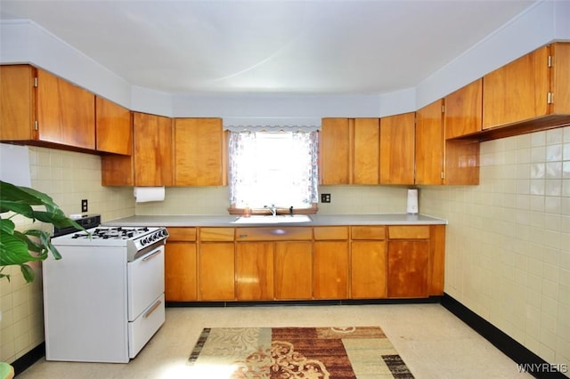 150 Leonard St, Lackawanna, NY 14218 - kitchen featuring white gas range, a sink, light countertops, brown cabinets, and light flooring
