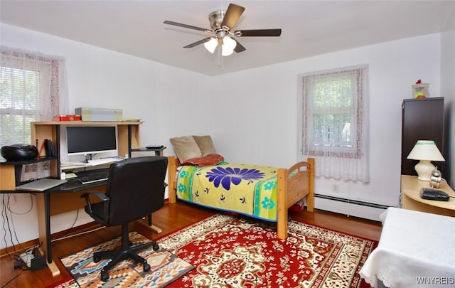 150 Leonard St, Lackawanna, NY 14218 - bedroom featuring baseboard heating, wood finished floors, an office area, and a ceiling fan