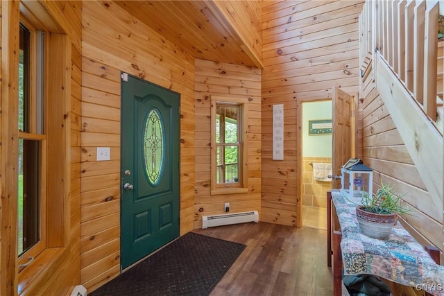 entrance foyer featuring baseboard heating, wooden walls, dark wood-type flooring, wood ceiling, and stairs