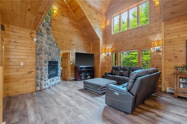 living room with high vaulted ceiling, plenty of natural light, wood finished floors, wooden walls, and baseboard heating