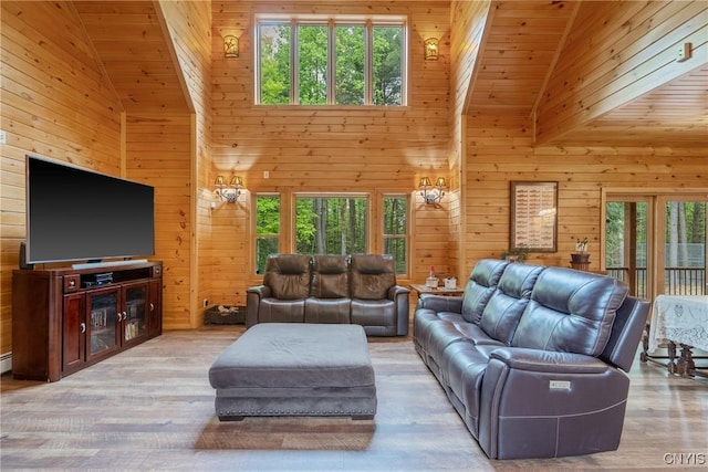 living room featuring high vaulted ceiling, wood walls, wood ceiling, and wood finished floors