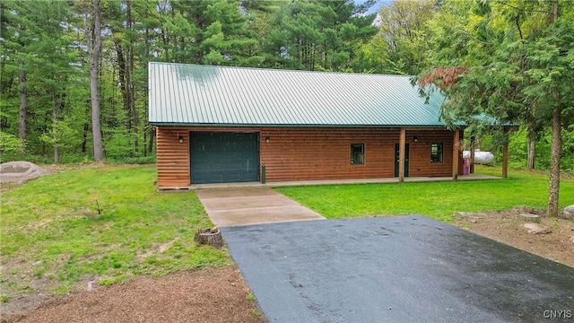 view of outdoor structure with asphalt driveway and a garage
