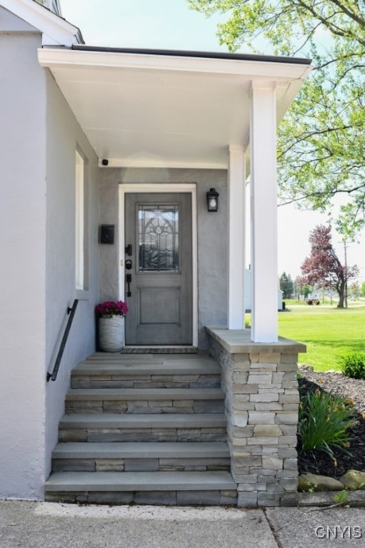 744 State Route 13, Cortlandville, NY 13045 - view of exterior entry featuring stucco siding and a yard