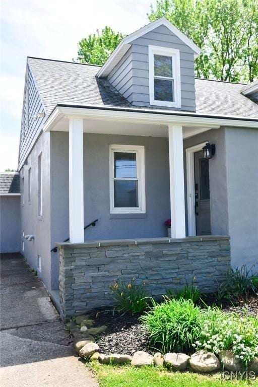744 State Route 13, Cortlandville, NY 13045 - bungalow with roof with shingles, stucco siding, stone siding, and covered porch