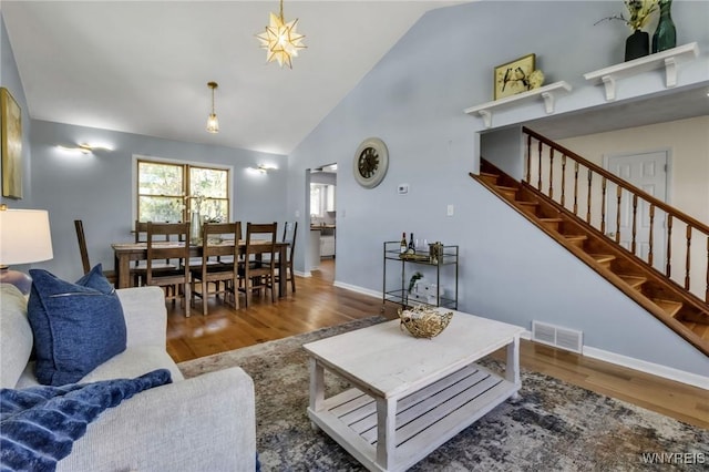 524 Pletcher Rd, Lewiston, NY 14092 - living area with wood finished floors, stairway, baseboards, and high vaulted ceiling