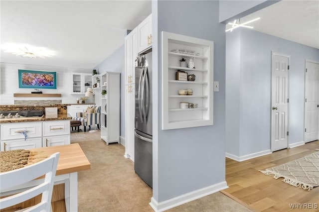 524 Pletcher Rd, Lewiston, NY 14092 - kitchen featuring white cabinets, freestanding refrigerator, light stone counters, built in shelves, and baseboards