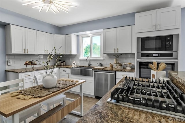 524 Pletcher Rd, Lewiston, NY 14092 - kitchen with appliances with stainless steel finishes, a sink, decorative backsplash, dark stone countertops, and white cabinets