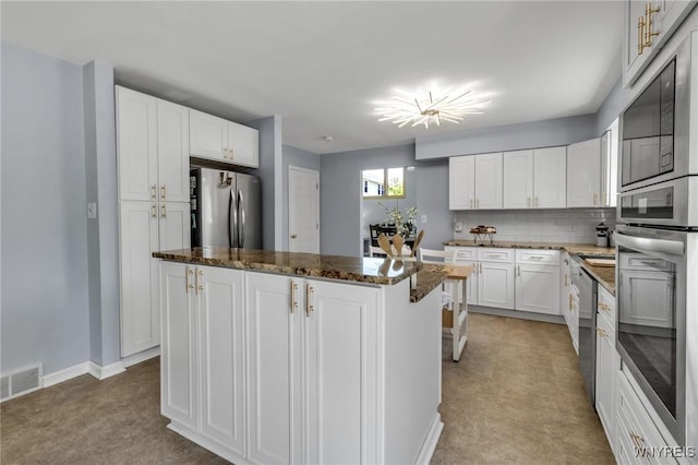 524 Pletcher Rd, Lewiston, NY 14092 - kitchen featuring stainless steel appliances, a center island, light carpet, white cabinetry, and dark stone countertops
