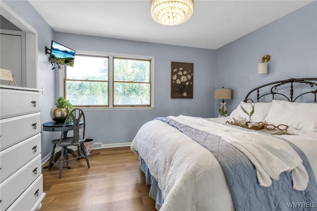 524 Pletcher Rd, Lewiston, NY 14092 - bedroom with wood finished floors, a chandelier, and baseboards