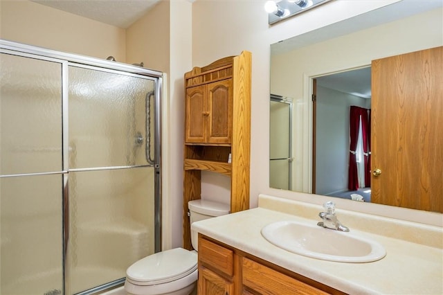 full bathroom with toilet, a stall shower, and vanity