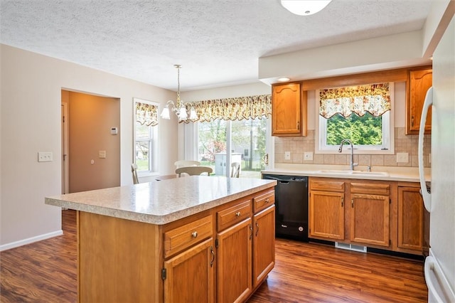 kitchen with a sink, dishwasher, dark wood finished floors, light countertops, and decorative backsplash
