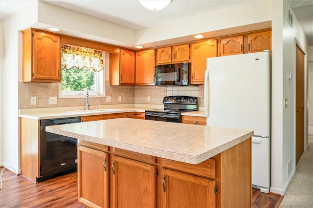 kitchen with black appliances, a sink, light countertops, decorative backsplash, and dark wood-style floors