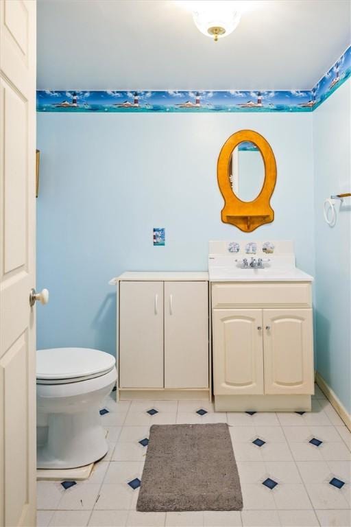 bathroom featuring tile patterned flooring, vanity, and toilet