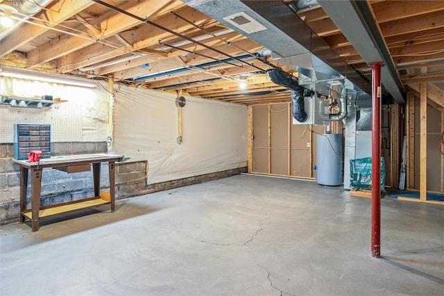 unfinished below grade area featuring heating unit, gas water heater, and a workshop area