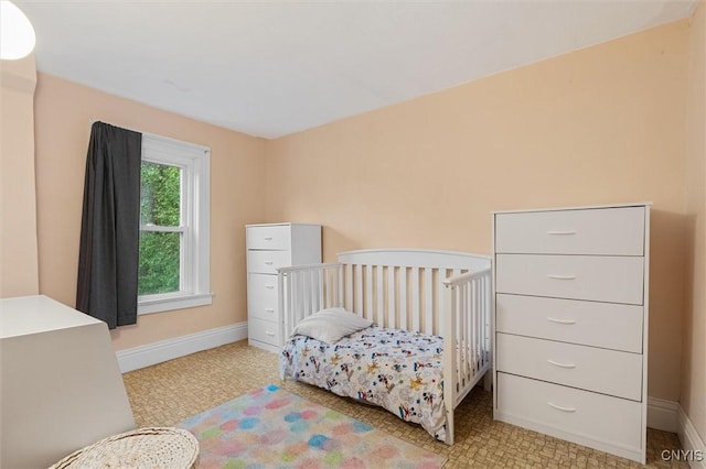 bedroom featuring baseboards and light floors