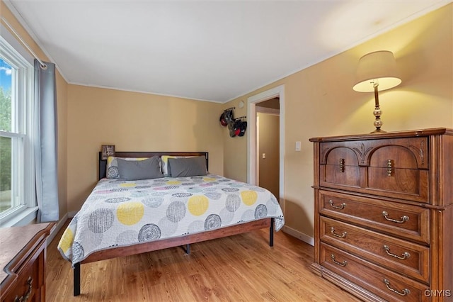 bedroom featuring light wood-style floors and baseboards