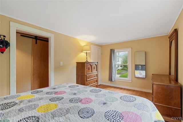 bedroom with light wood finished floors and baseboards