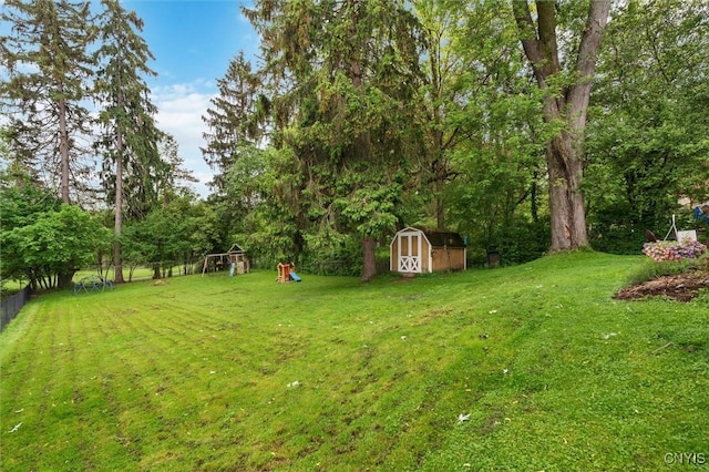 view of yard featuring a playground, a shed, and an outdoor structure