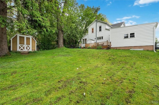 view of grassy yard featuring a shed, an outbuilding, and a deck