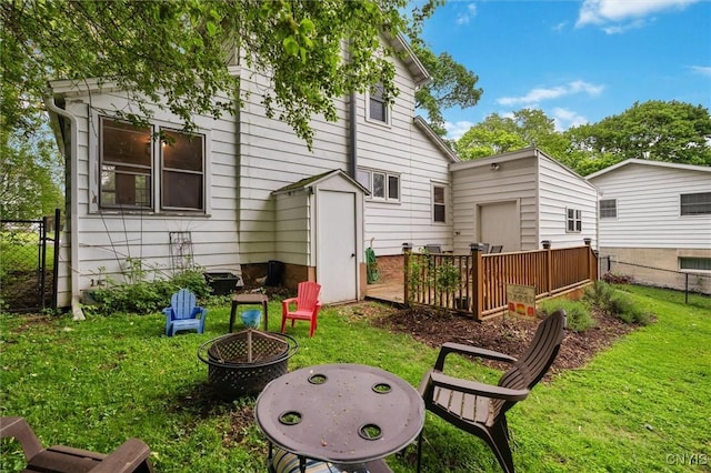 rear view of property featuring an outdoor fire pit and a deck
