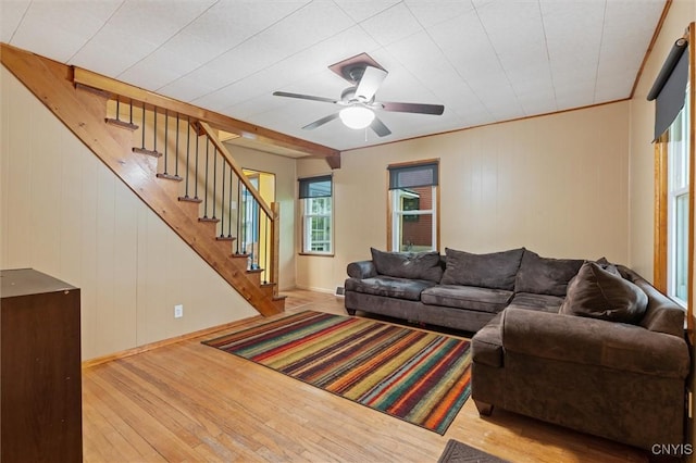 living room with wood finished floors, stairs, ceiling fan, and baseboards