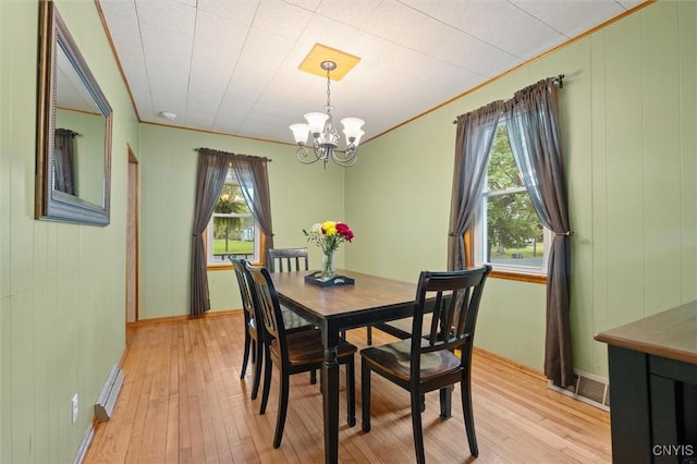 dining room with a chandelier, plenty of natural light, and light wood-style flooring
