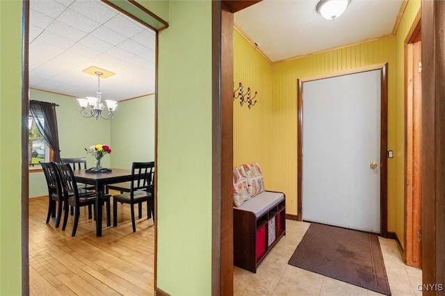 entrance foyer with a chandelier, ornamental molding, and baseboards