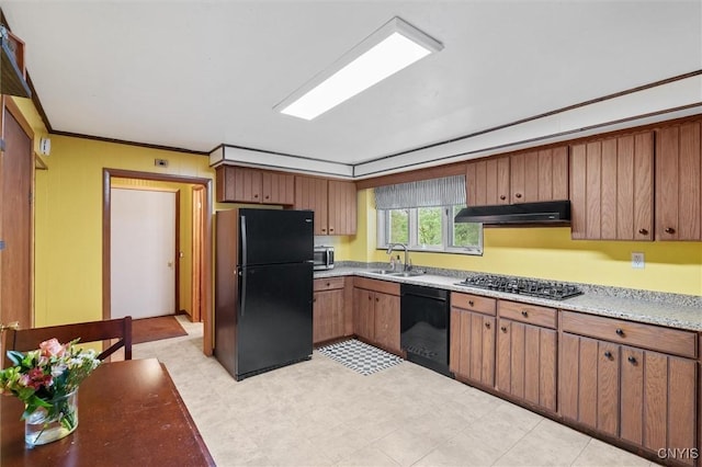 kitchen with black appliances, under cabinet range hood, a sink, brown cabinets, and light flooring